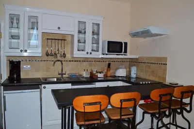 a kitchen with white cabinets and a black counter top at The Town House in Douglas