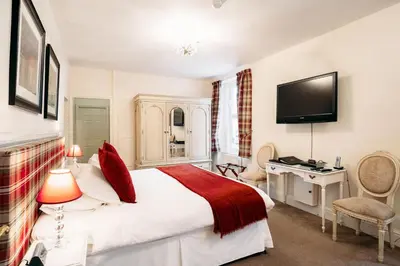 a hotel room with a bed and a television at The Town House in Douglas