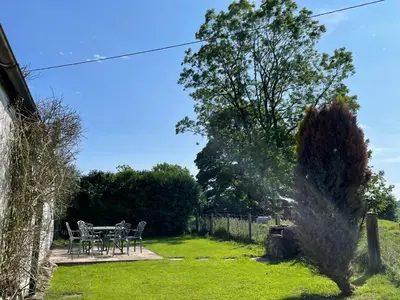 a garden with a table and chairs in the grass at Barcloy Honey House in Kirkcudbright