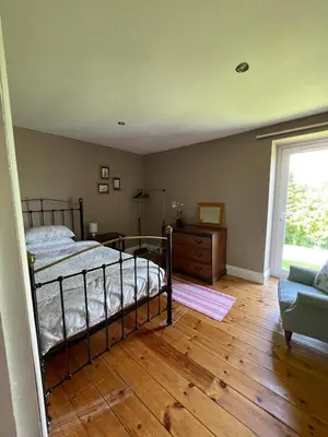 a bedroom with a bed and a couch and a window at Barcloy Honey House in Kirkcudbright