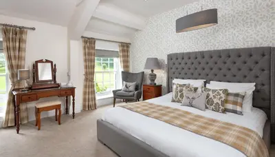 a bedroom with a bed and a desk and a mirror at The King's Head in Thirlmere