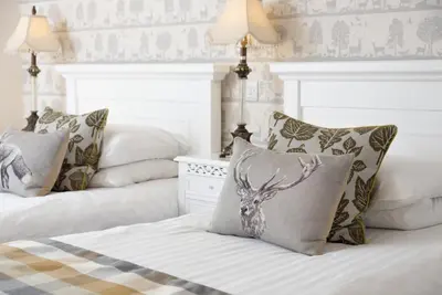a bedroom with two beds with pillows and a deer head pillow at The King's Head in Thirlmere