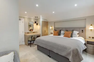 a bedroom with a large bed and a desk at The Borrowdale Hotel in Keswick