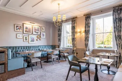 a restaurant with tables and chairs and a chandelier at The Borrowdale Hotel in Keswick