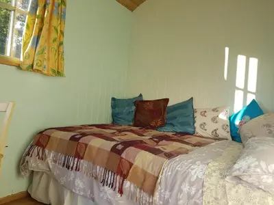 a bedroom with a bed and a window at Shepherds hut Dolly wagon in Keswick