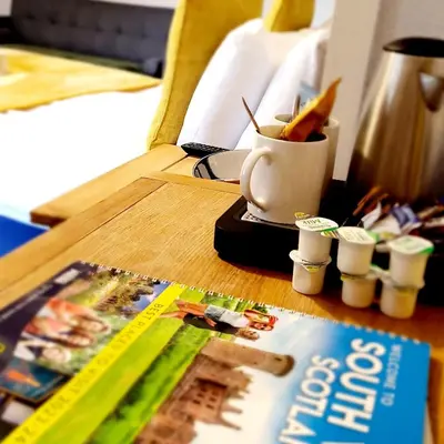 a table with a book and a cup of pens at The Market Inn Hotel in Castle Douglas