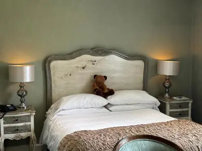 a teddy bear sitting on top of a bed at Dale Head Hall Lakeside Hotel in Keswick