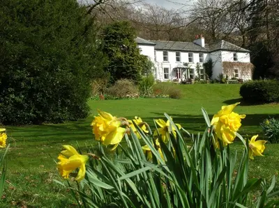 a house with yellow flowers in front of a yard at Dale Head Hall Lakeside Hotel in Keswick