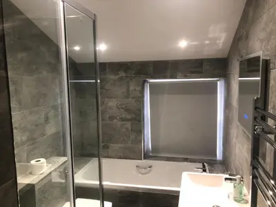 a bathroom with a shower and a toilet and a sink at Dale Head Hall Lakeside Hotel in Keswick