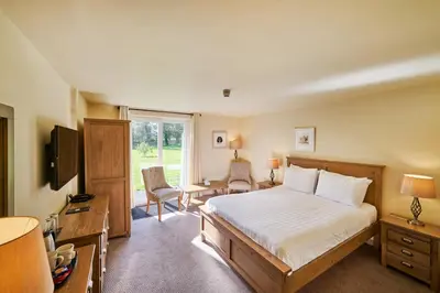a bedroom with a large bed and a television at Comis Hotel & Golf Resort in Douglas