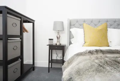 a bedroom with a bed with a yellow pillow and a night stand at The Annex in Carlisle