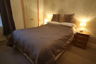 a bedroom with a large bed with two lamps at West View in Keswick