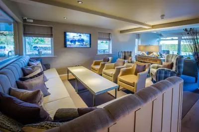 a waiting room with couches and chairs and a tv at The Grand at Grasmere in Grasmere