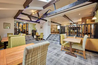 a restaurant with a table and chairs and stairs at The Old Ginn House Inn in Great Clifton
