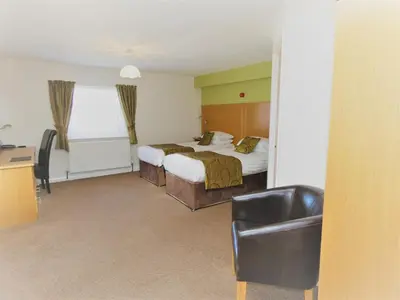 a hotel room with a bed and a chair at The Old Ginn House Inn in Great Clifton