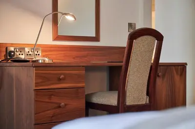 a desk with a chair and a lamp on it at The Old Ginn House Inn in Great Clifton