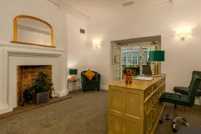 a living room with a desk and a fireplace at Sella Park Country House Hotel in Seascale