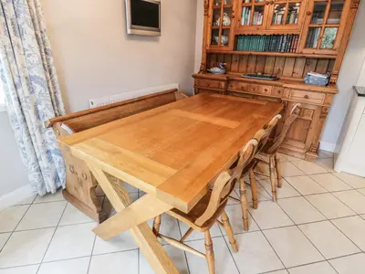 a wooden table and chairs in a kitchen at Bracken Holiday Cottage in Dalbeattie
