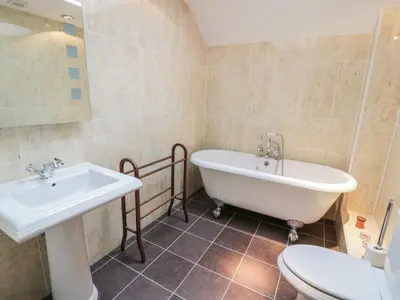 a bathroom with a tub and a sink and a toilet at Bracken Holiday Cottage in Dalbeattie