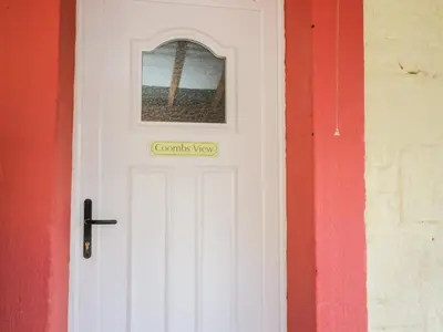 a white door with a window and a cross on it at Coombs View in Low Hesket