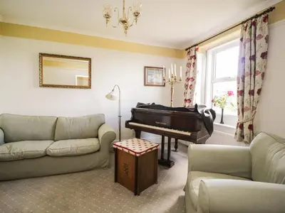 a living room with a piano and a couch at Coombs View in Low Hesket