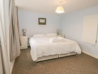 a bedroom with a white bed with towels on it at 2 Park Nook Close in Waberthwaite
