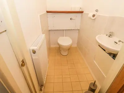 a small bathroom with a toilet and a sink at 2 Park Nook Close in Waberthwaite
