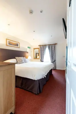 a bedroom with a large bed and a window at The Britannia Inn in Elterwater