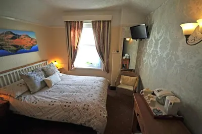 a hotel room with a bed and a window at Abacourt House in Keswick