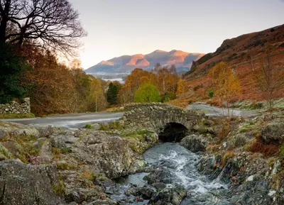a bridge over a river in the mountains at Abacourt House in Keswick