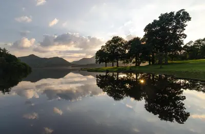 a view of a lake with trees and mountains at Abacourt House in Keswick