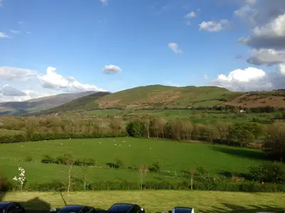 a green field with sheep grazing in the hills at Embleton Spa Hotel & Apartments in Embleton