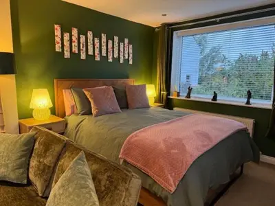 a bedroom with green walls and a bed and a window at The Stables @ The Forge Cronk Y Voddy in Saint Johns