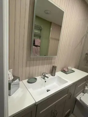 a bathroom with a white sink and a mirror at The Stables @ The Forge Cronk Y Voddy in Saint Johns