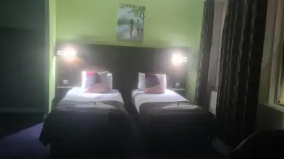 a room with two beds in a room at The Queensberry Hotel in Dumfries