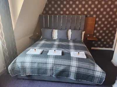 a bedroom with a bed with two towels on it at The Queensberry Hotel in Dumfries