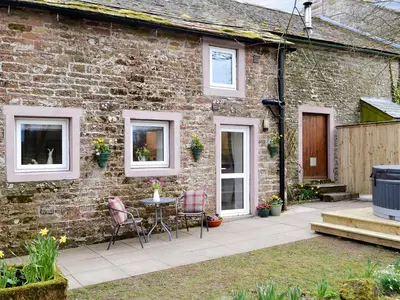 a brick house with a patio and a table and chairs at Farmhouse Cottage - Uk1285 in Westward