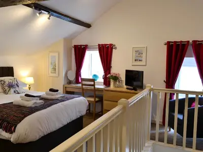 a bedroom with a bed and a desk with a television at Farmhouse Cottage - Uk1285 in Westward
