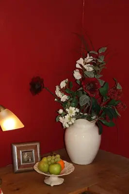 a vase with flowers on a table with a plate of fruit at Overwater Hall in Bassenthwaite