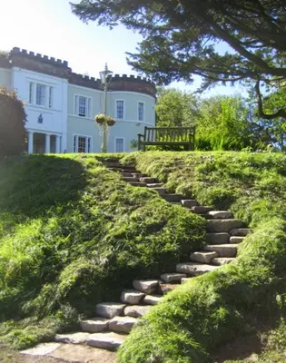 a stone path in front of a white house at Overwater Hall in Bassenthwaite