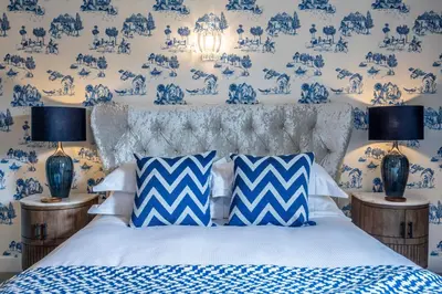 a bedroom with blue and white wallpaper and a bed at Georgian House Hotel in Whitehaven