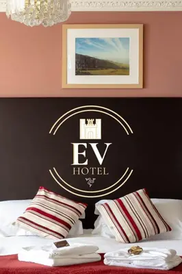 a bedroom with a bed with a hotel sign on the wall at Ellan Vannin Hotel in Douglas