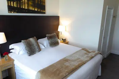 a bedroom with a large white bed with two pillows at Ellan Vannin Hotel in Douglas
