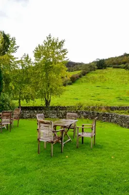a group of wooden tables and chairs in a field at The Lady Maxwell Room at Buittle Castle in Dalbeattie