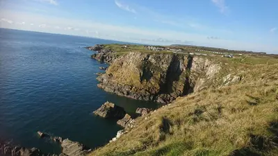 an aerial view of a rocky cliff next to the ocean at 4 Laigh Isle in Isle of Whithorn