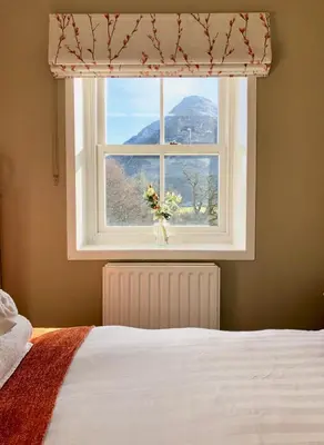 a bedroom with a window with a view of a mountain at Kirkstile Inn in Loweswater