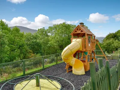 a playground with a slide and a house at Grajo Cottage - Uk1284 in Threlkeld