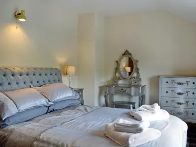 a bedroom with a bed and a dresser and a mirror at Grajo Cottage - Uk1284 in Threlkeld