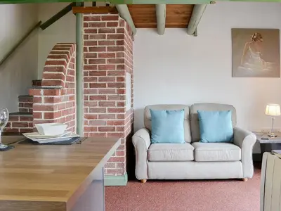 a living room with a couch and a brick wall at Darci's Lodge - Uk1297 in Threlkeld