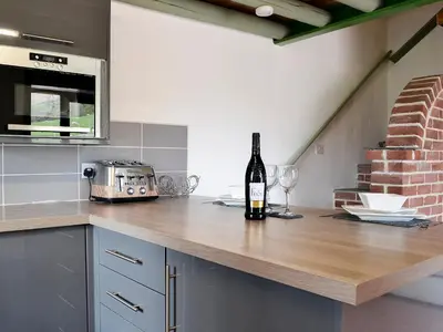 a bottle of wine sitting on a counter in a kitchen at Darci's Lodge - Uk1297 in Threlkeld